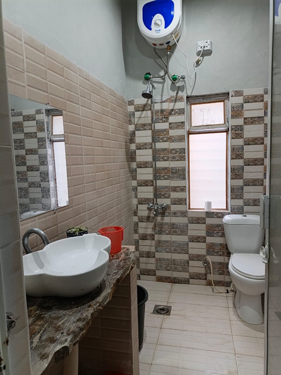Tiled bathroom with vessel sink, shower and water heater